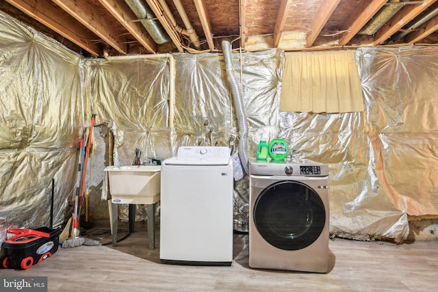 laundry room with washer and clothes dryer, sink, and wood-type flooring