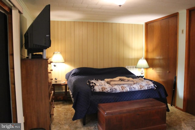 carpeted bedroom featuring wooden walls