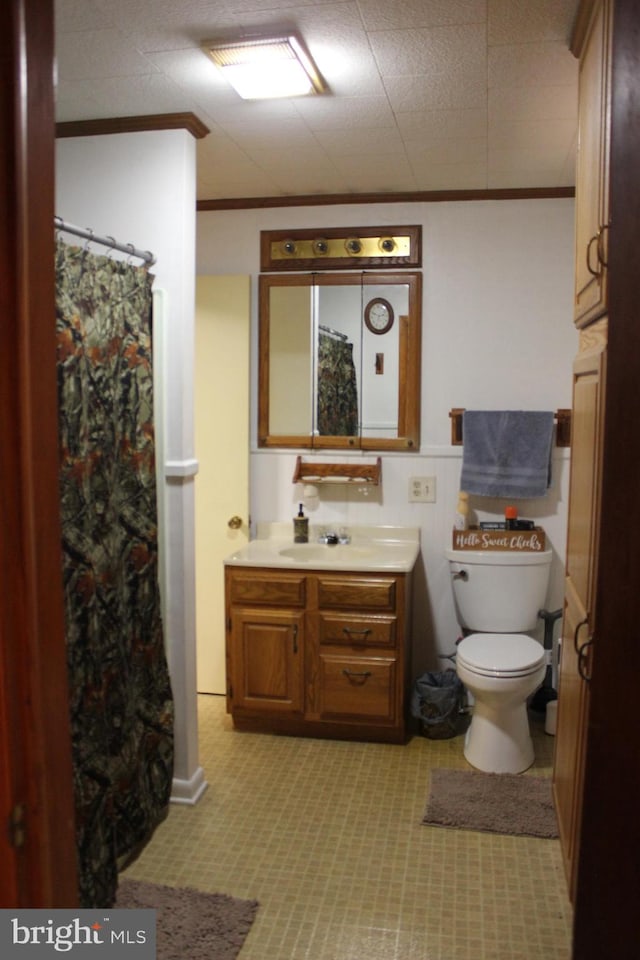 bathroom featuring curtained shower, ornamental molding, vanity, and toilet