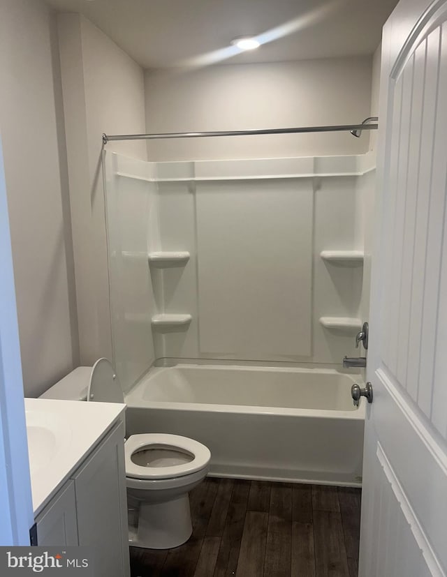 full bathroom with wood-type flooring,  shower combination, vanity, and toilet