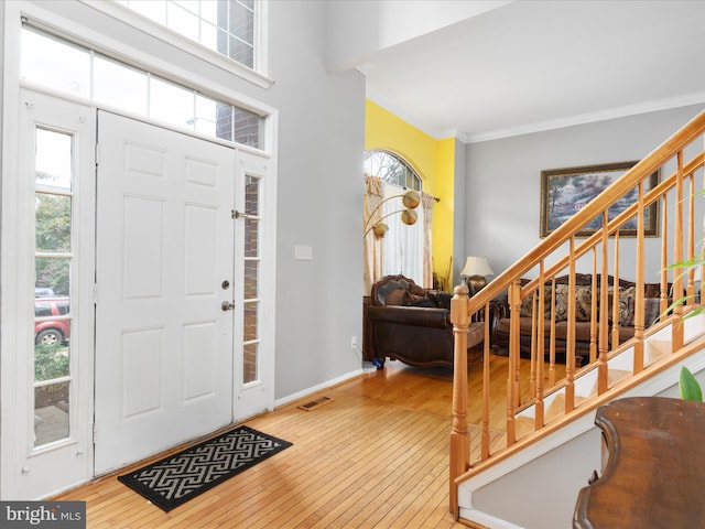 entrance foyer with wood-type flooring and ornamental molding