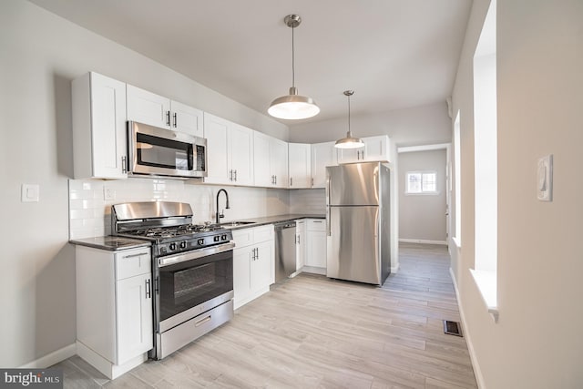 kitchen with light hardwood / wood-style floors, white cabinetry, and stainless steel appliances