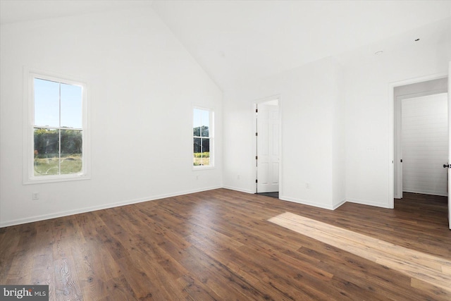 empty room with dark hardwood / wood-style flooring, high vaulted ceiling, and plenty of natural light