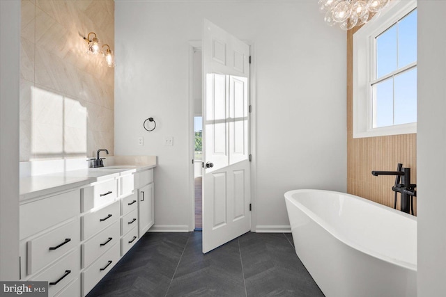 73 King Richard Rd, Berlin, MD 21811 - bathroom with a freestanding tub, tile patterned floors, vanity, baseboards, and an inviting chandelier