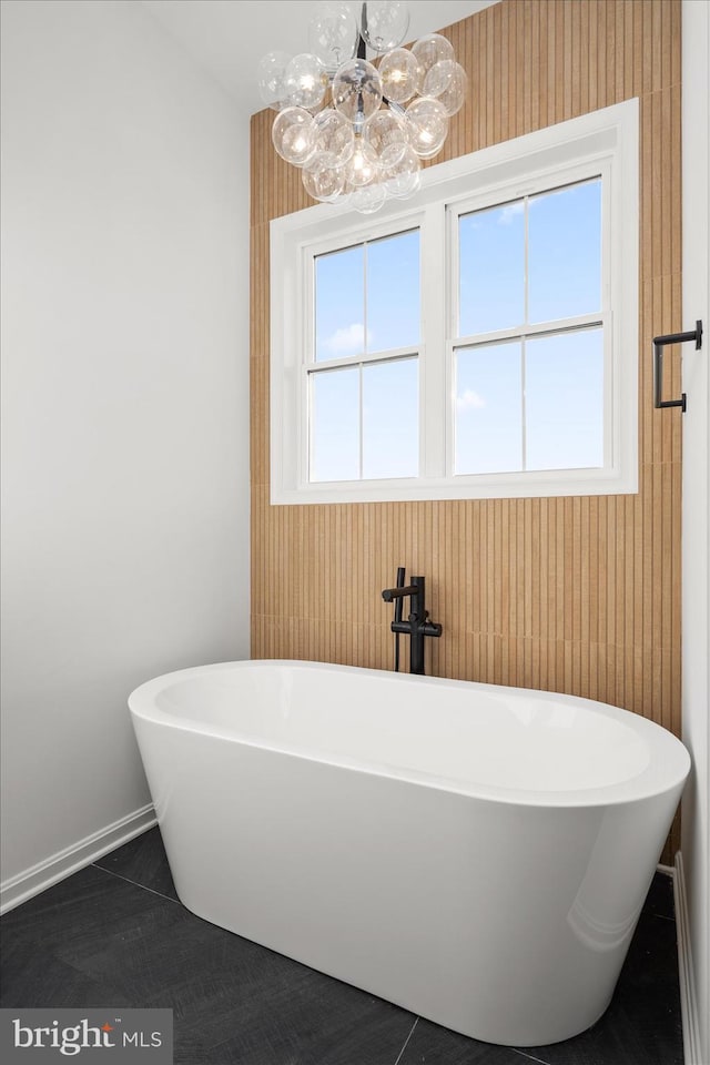 bathroom with a washtub, tile patterned floors, and wooden walls