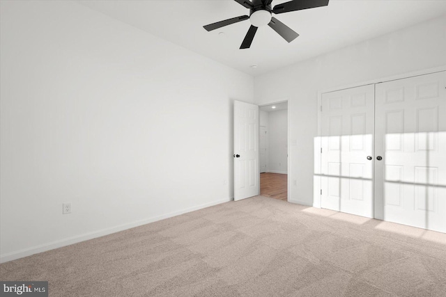 unfurnished bedroom featuring a closet, light colored carpet, and ceiling fan