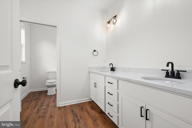 bathroom with hardwood / wood-style floors, vanity, and toilet