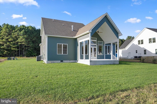 rear view of house with a sunroom, central air condition unit, and a yard