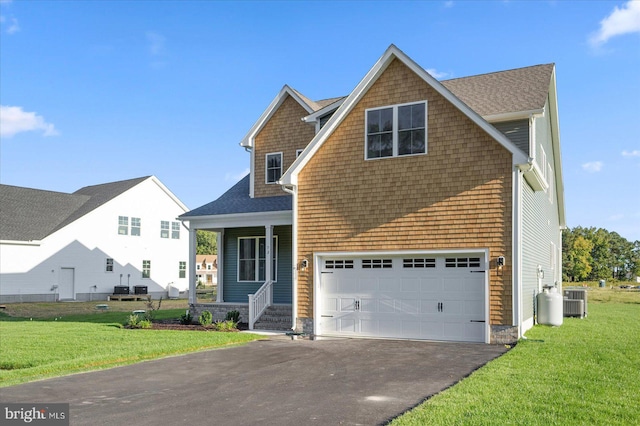 view of front of home featuring a front lawn, central AC unit, and a garage