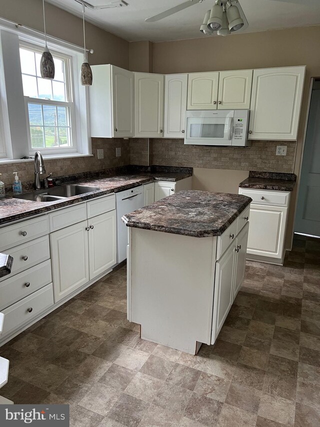 kitchen featuring white cabinets, white appliances, a center island, ceiling fan, and sink