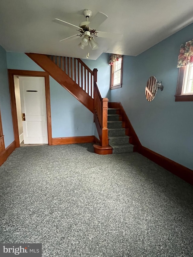 unfurnished living room with ceiling fan, carpet floors, and plenty of natural light