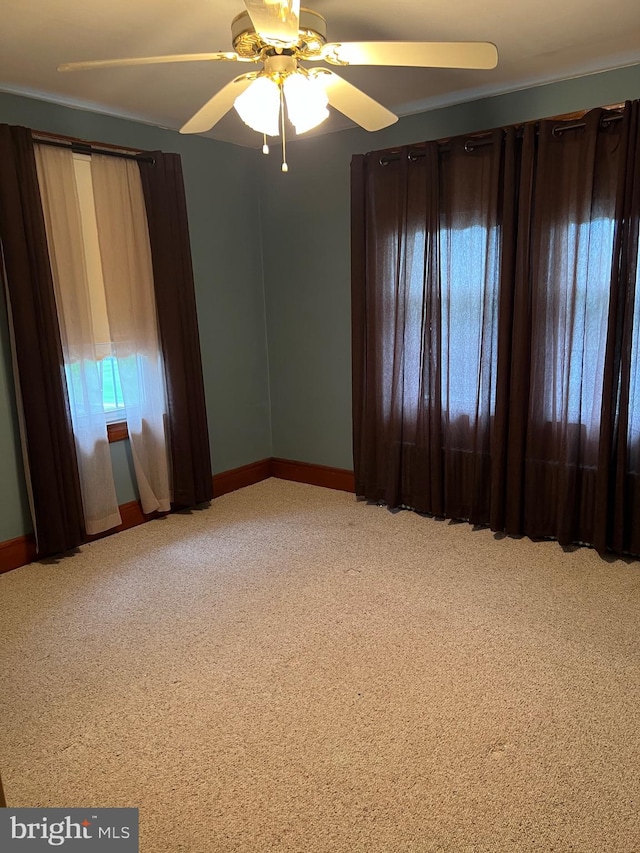 carpeted empty room featuring ceiling fan