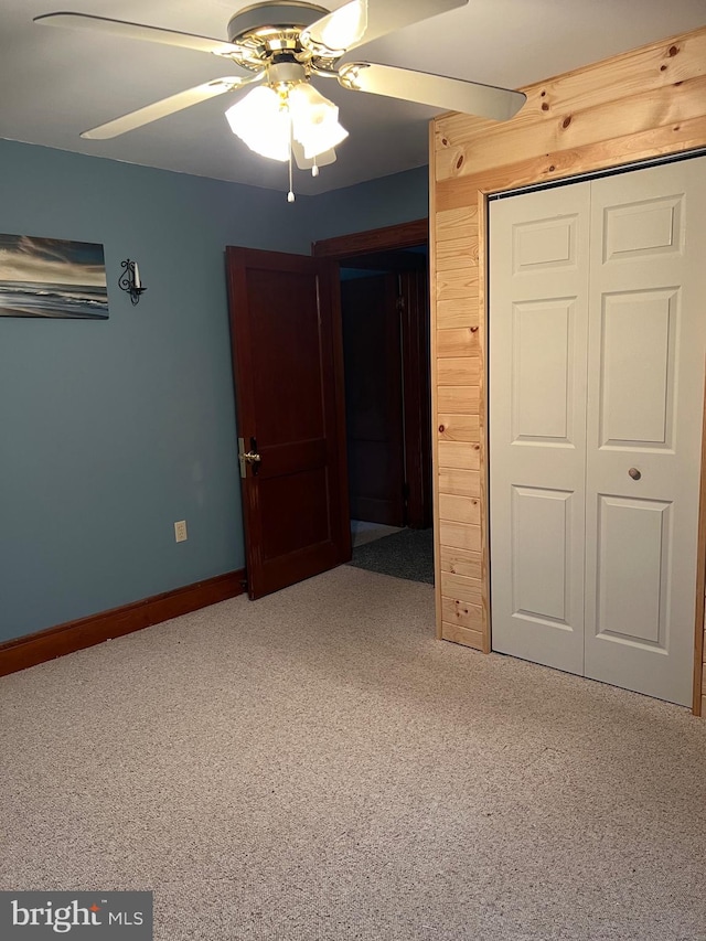 unfurnished bedroom featuring carpet flooring, ceiling fan, and a closet