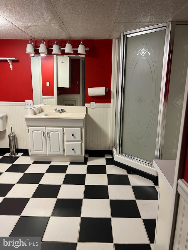 bathroom featuring vanity, a paneled ceiling, and a shower with door