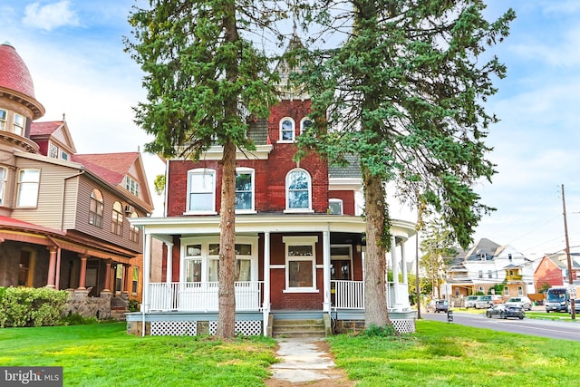 view of front facade with a front yard and covered porch