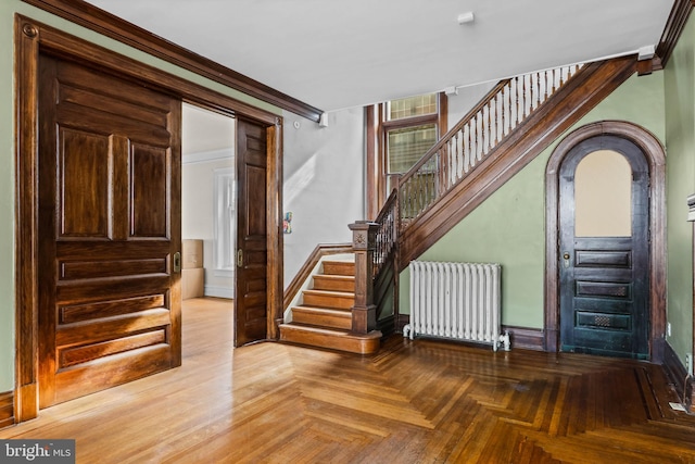 stairs featuring parquet flooring, crown molding, and radiator heating unit