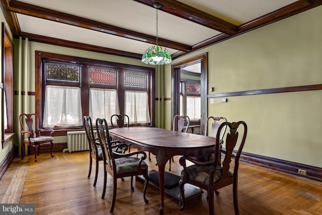 dining room featuring radiator heating unit, wood-type flooring, and beam ceiling