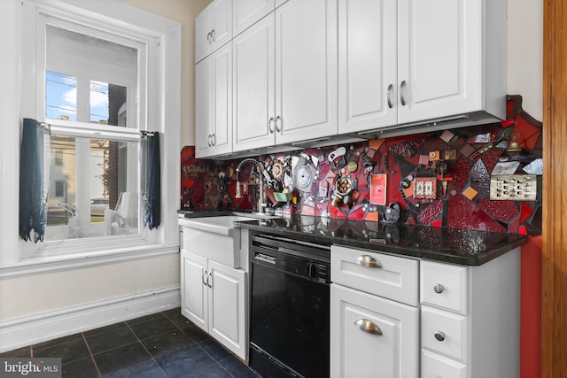 kitchen with dark tile patterned flooring, white cabinets, dishwasher, and backsplash