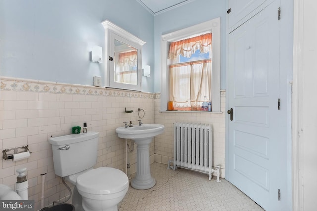 bathroom featuring sink, tile walls, toilet, and radiator heating unit