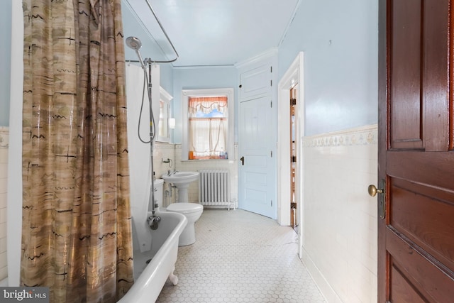 bathroom with tile walls, radiator, toilet, and shower / tub combo