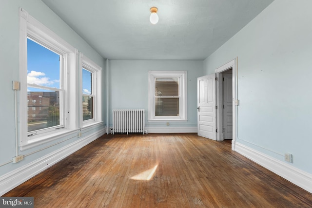 empty room with radiator and hardwood / wood-style floors