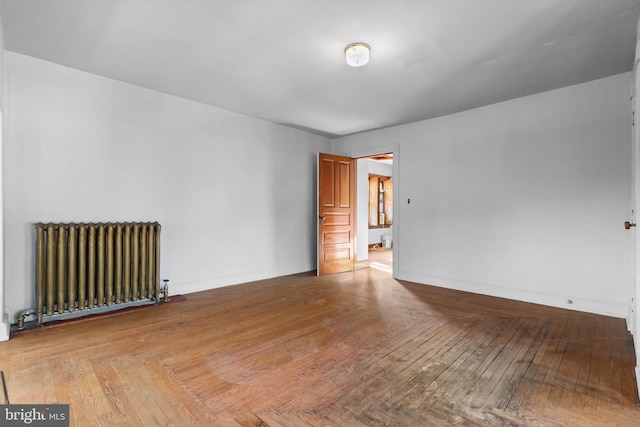 unfurnished room featuring radiator and light hardwood / wood-style floors