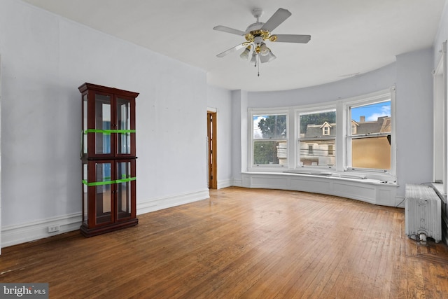 spare room with radiator, ceiling fan, and hardwood / wood-style floors