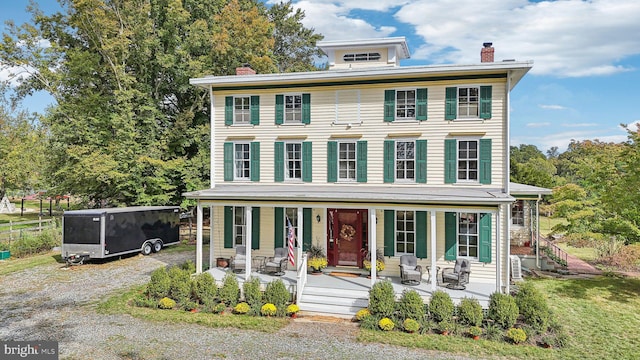 view of front of property with covered porch and a chimney