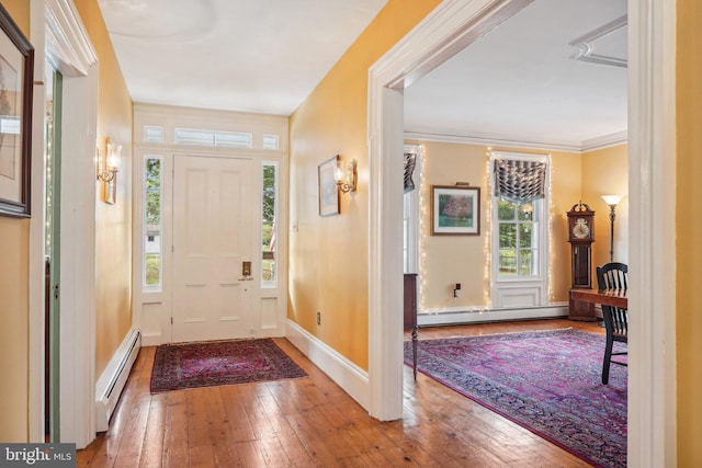foyer with ornamental molding, baseboards, hardwood / wood-style floors, and baseboard heating