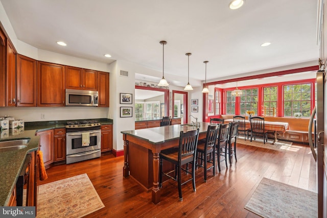 kitchen with visible vents, a kitchen breakfast bar, dark wood finished floors, recessed lighting, and stainless steel appliances