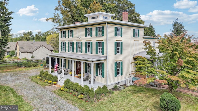 view of front of house with a porch, fence, a front lawn, a chimney, and driveway