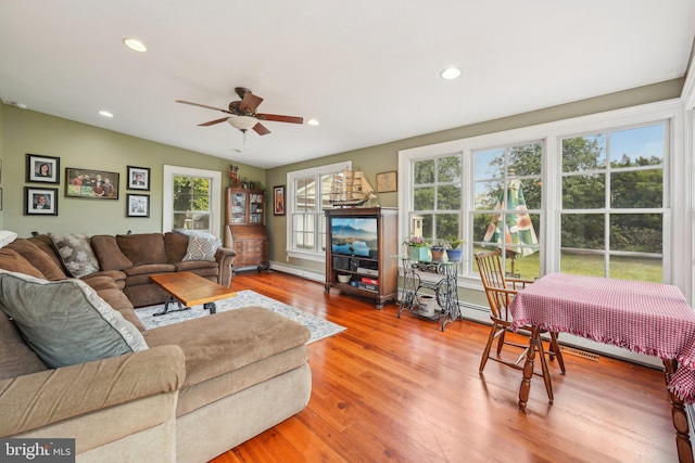 living area featuring a baseboard radiator, wood finished floors, ceiling fan, and recessed lighting