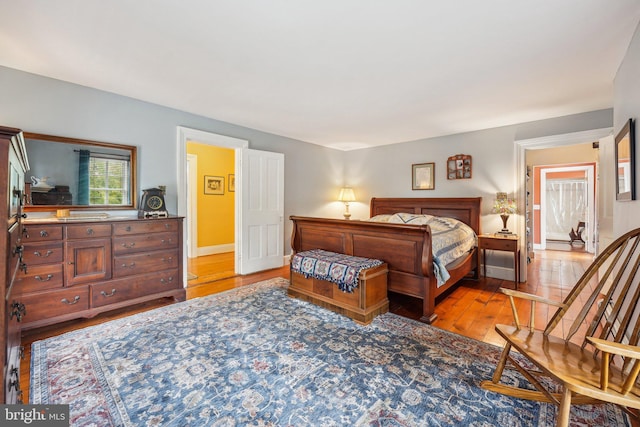 bedroom featuring light wood finished floors and baseboards