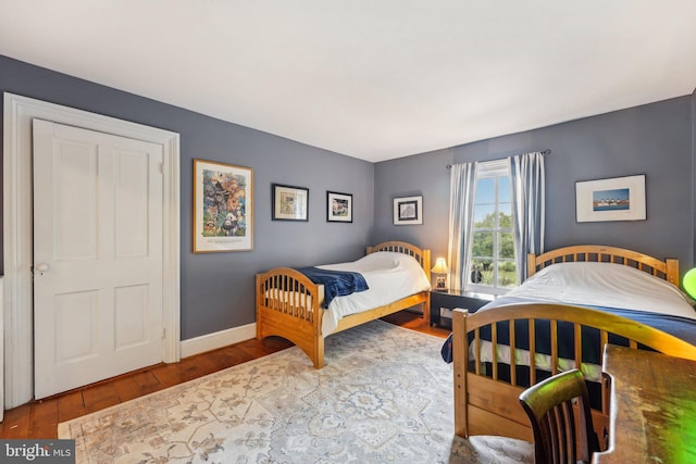 bedroom with hardwood / wood-style flooring and baseboards
