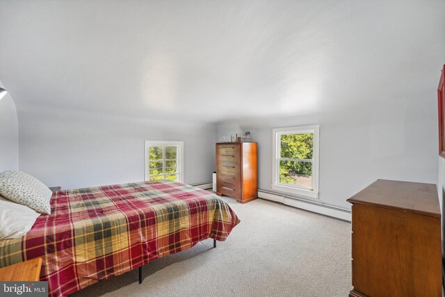 bedroom featuring baseboard heating, multiple windows, and carpet floors