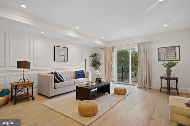 living room with ornamental molding and light wood-type flooring