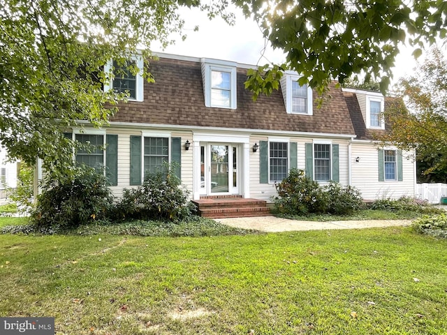 cape cod house with a front yard