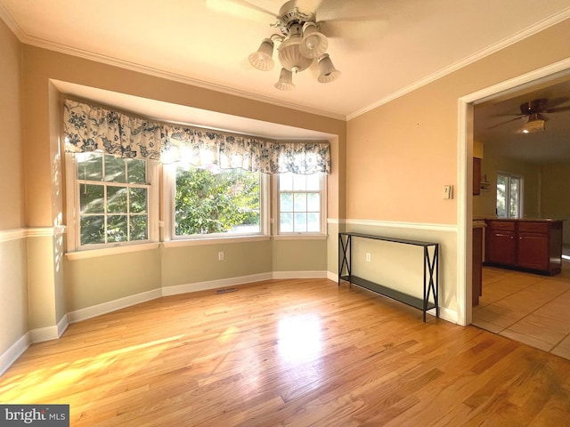 unfurnished room with ceiling fan, light hardwood / wood-style flooring, and ornamental molding