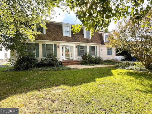 cape cod home featuring a front yard