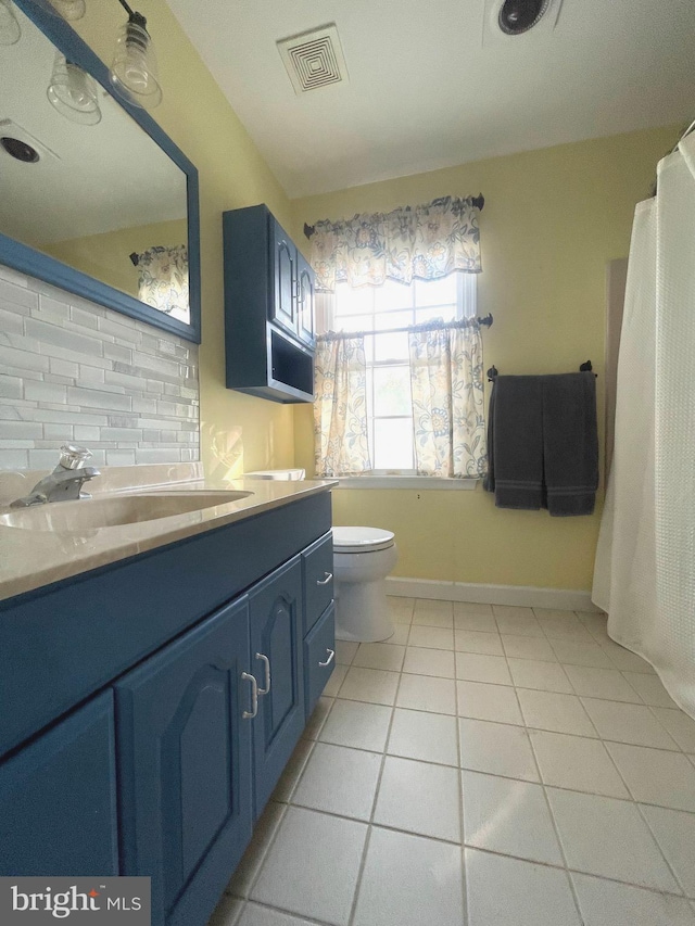 bathroom featuring tile patterned floors, tasteful backsplash, vanity, and toilet