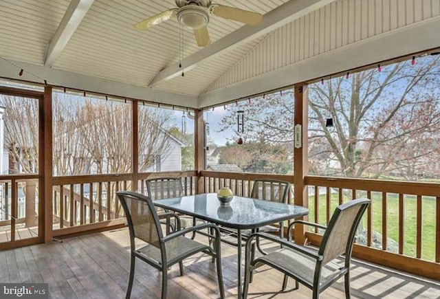 sunroom with ceiling fan, lofted ceiling with beams, and a wealth of natural light