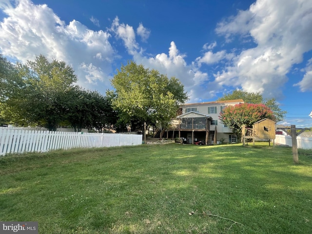 view of yard featuring a wooden deck and a storage shed