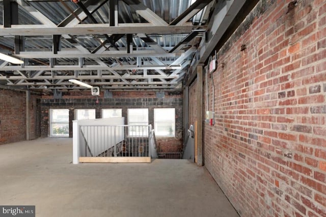 interior space featuring concrete floors and brick wall