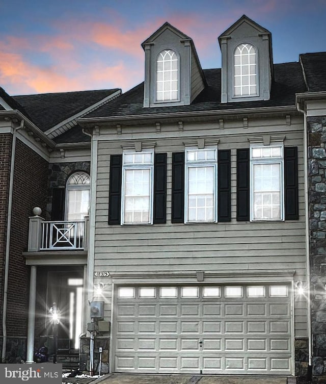 view of front facade with a balcony and a garage