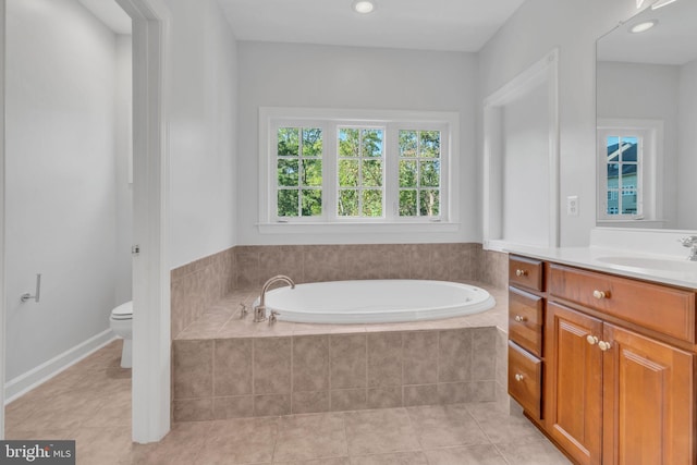 bathroom with tile patterned flooring, tiled bath, vanity, and toilet