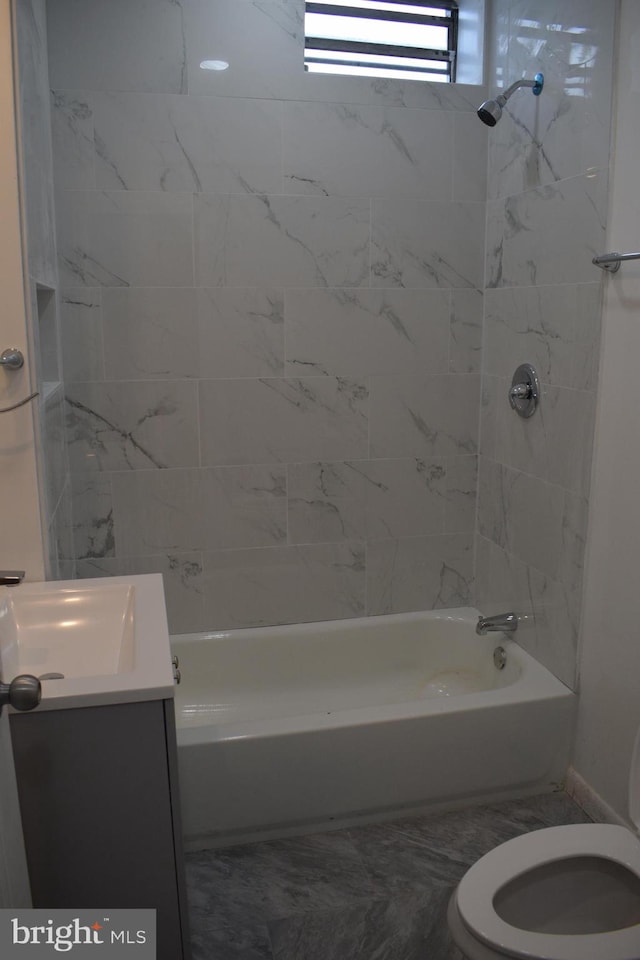 full bathroom with tiled shower / bath, vanity, and toilet