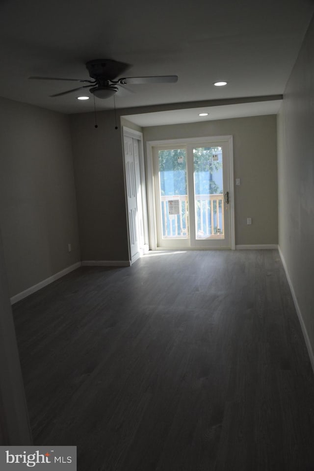 spare room featuring dark hardwood / wood-style flooring and ceiling fan