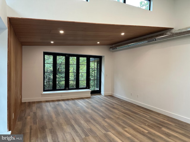 spare room featuring wood ceiling, wood-type flooring, and vaulted ceiling