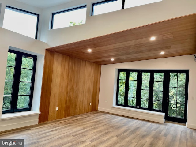 unfurnished room featuring high vaulted ceiling, wooden ceiling, and light wood-type flooring