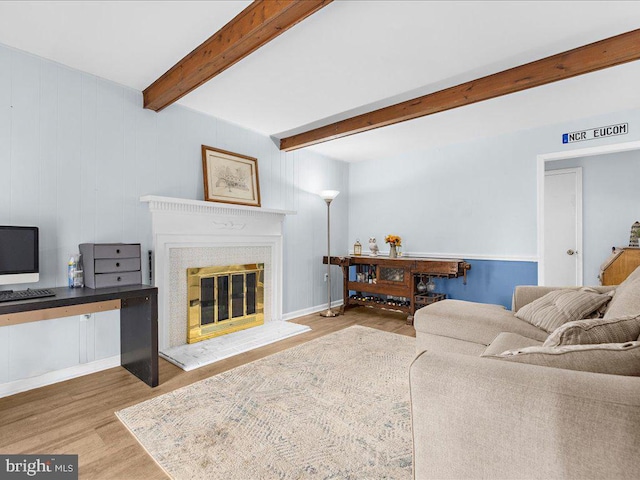 living room with hardwood / wood-style floors, beamed ceiling, and a fireplace